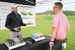 image of men discuss golf balls in a retail environment
